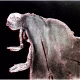 A woman crawls along the ground. She is bald, skeletal and covered in a removal blanket. Printed and tinted/shaded in black and red.