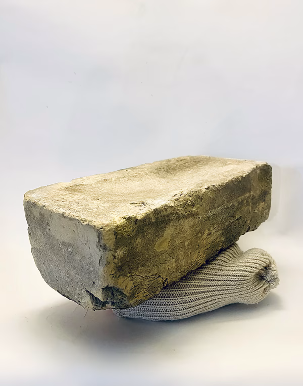 Soft sculpture head crushed by a brick