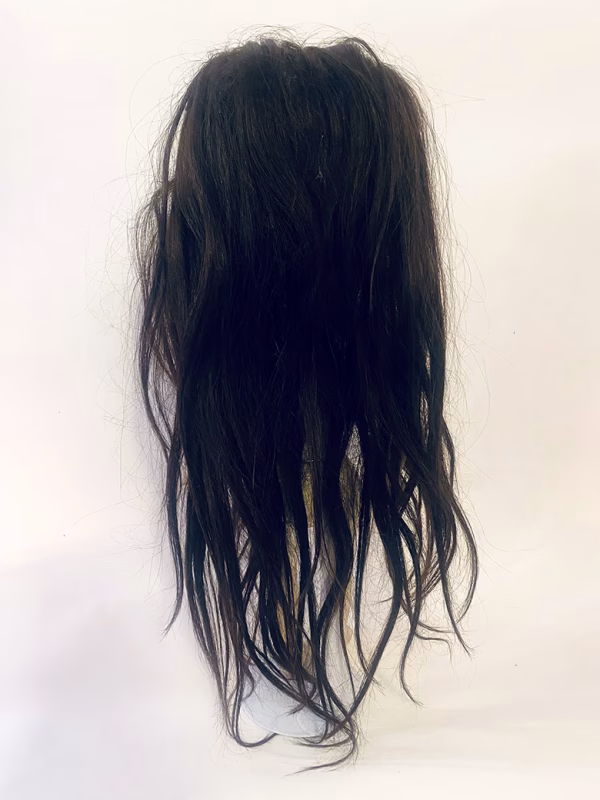 Uncanny girl doll with long dark brown hair. Backside.