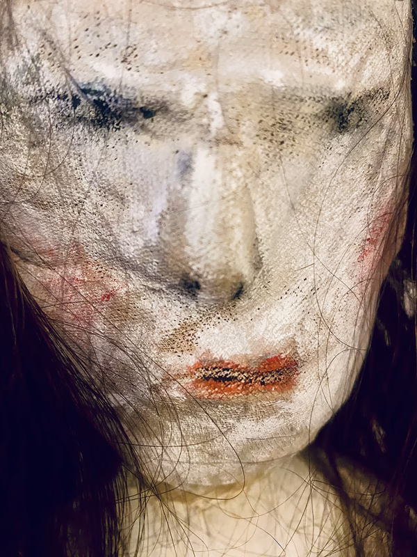 Uncanny girl doll with long dark brown hair. Face detail.