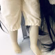 Uncanny girl doll with long dark brown hair. Legs and feet.