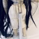 Uncanny girl doll with long dark brown hair. Back view with stand.