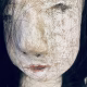 Uncanny girl doll with long dark brown hair. Face detail.