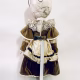A doll wearing a sage green velvet and cream cotton dress. With a kilner jar clip over its head.