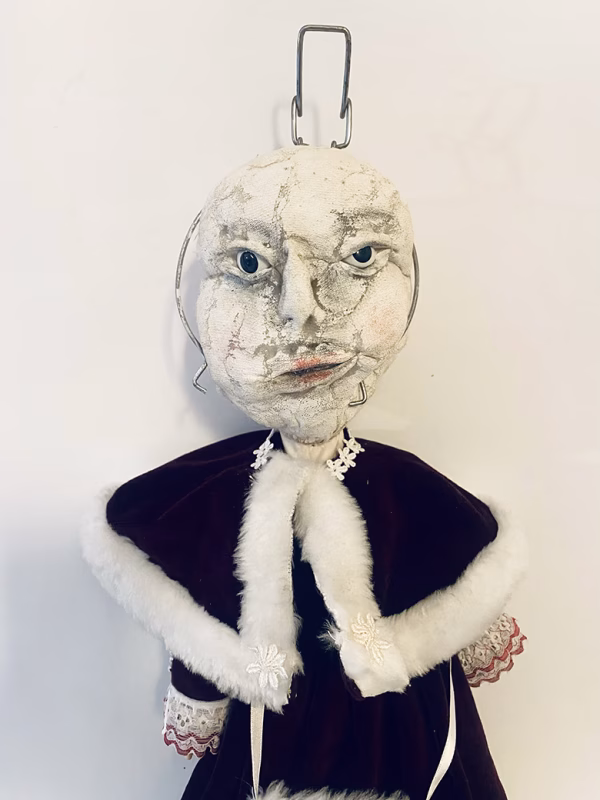 Hacked doll with a Kilner jar clip around its 'ugly' uncanny head.