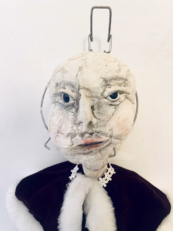 Hacked doll with a Kilner jar clip around its 'ugly' uncanny head.