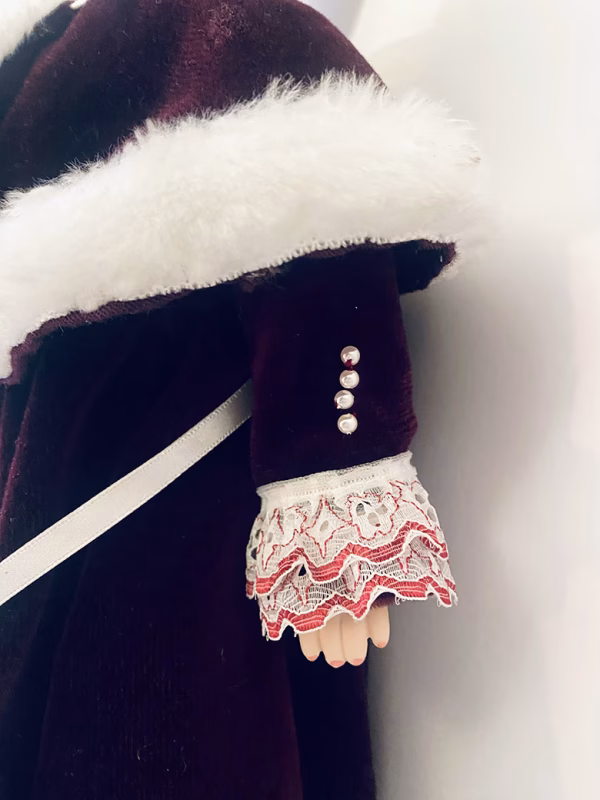 Doll detail: velvet dress with white fur trim and muff.