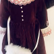 Doll detail: dark red velvet dress with white fur trim and muff.
