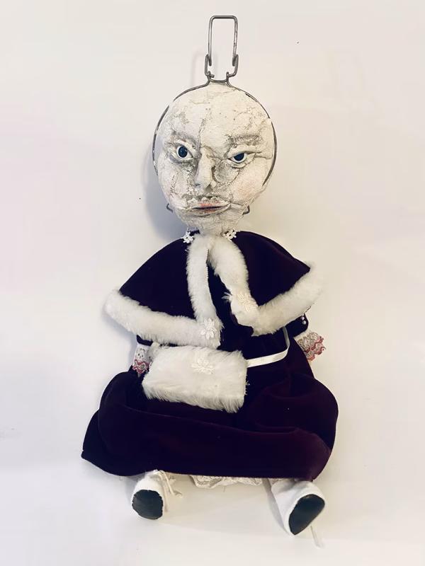 Hacked doll with a Kilner jar clip around its 'ugly' uncanny head.