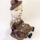 Hacked doll with decayed silk dress. The original ‘pretty’ head is replaced with an oversized, bald, uncanny head.