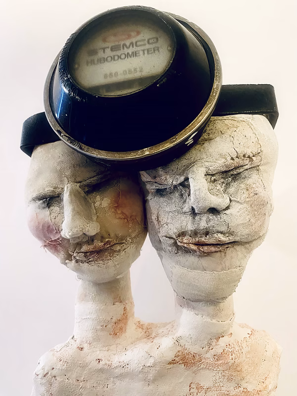 Double headed skeletal torso sculpture crowned with a vintage mechanical hubodometer