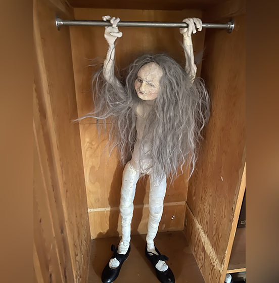 Human figure with long grey hair in a wardrobe