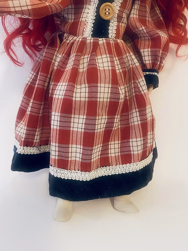 Uncanny girl doll with checkered dress (lower part).