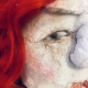 Uncanny girl doll with checkered dress and wavy red hair (face close-up).