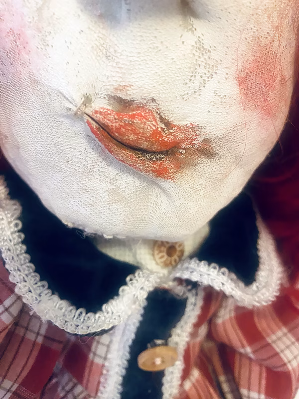 Uncanny girl doll with checkered dress (face close-up).