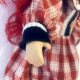 Uncanny girl doll with checkered dress and wavy red hair (detail).