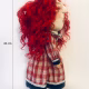 Uncanny girl doll with checkered dress and wavy red hair.
