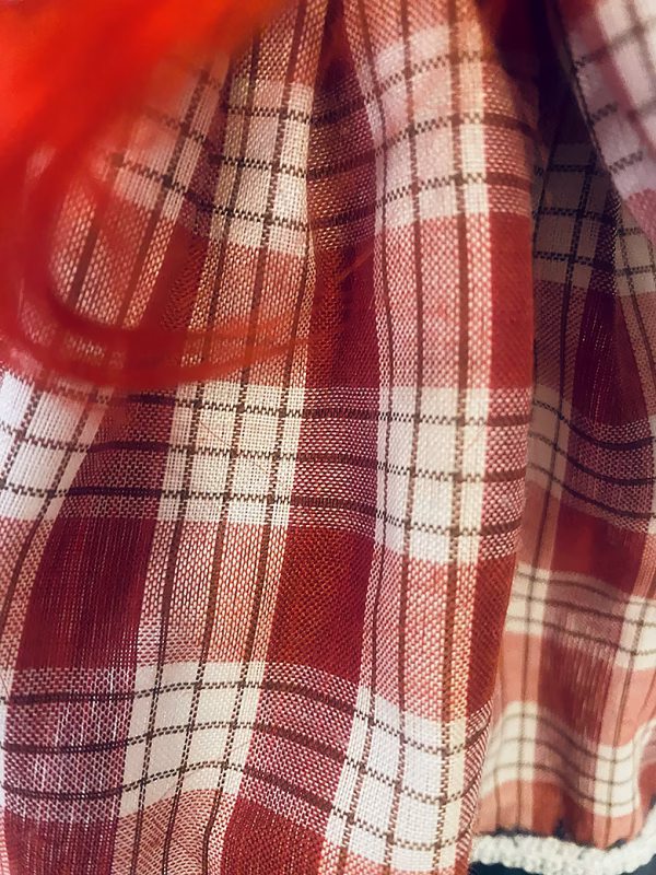Uncanny girl doll with checkered dress (detail).